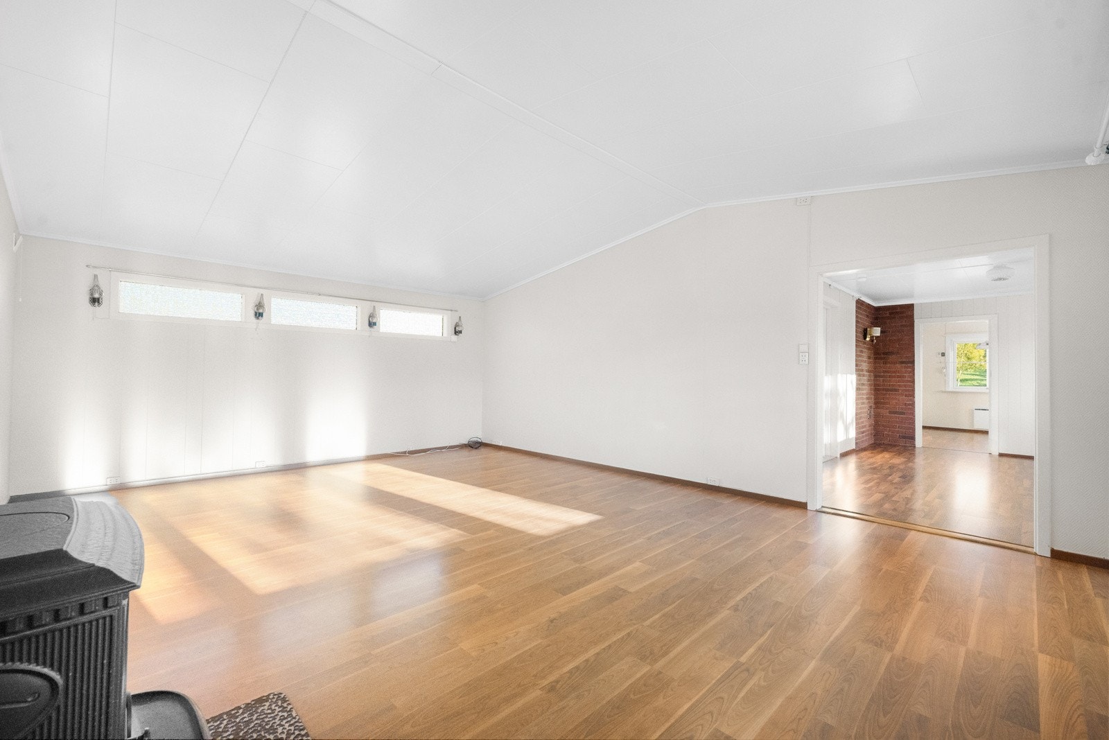 Den tilbygde stuen med vedovn gir rikelig med plass for både familiehygge og sosiale sammenkomster Galleribilde