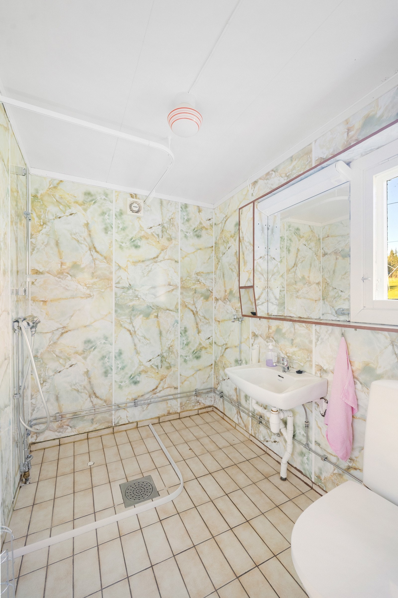 Badet har fliser på gulvet, respatex plater på vegger og himlingsplater i taket Galleribilde