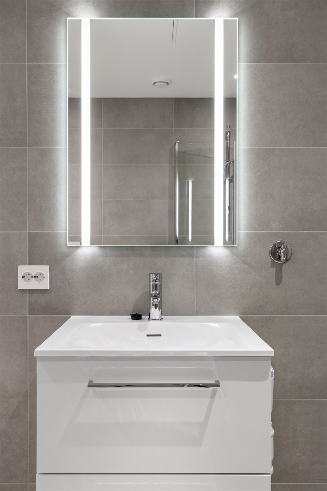 Stilrent og funksjonelt bad med tidløst design, smarte løsninger og opplegg for vaskemaskin - praktisk for hverdagsbruk. Galleribilde