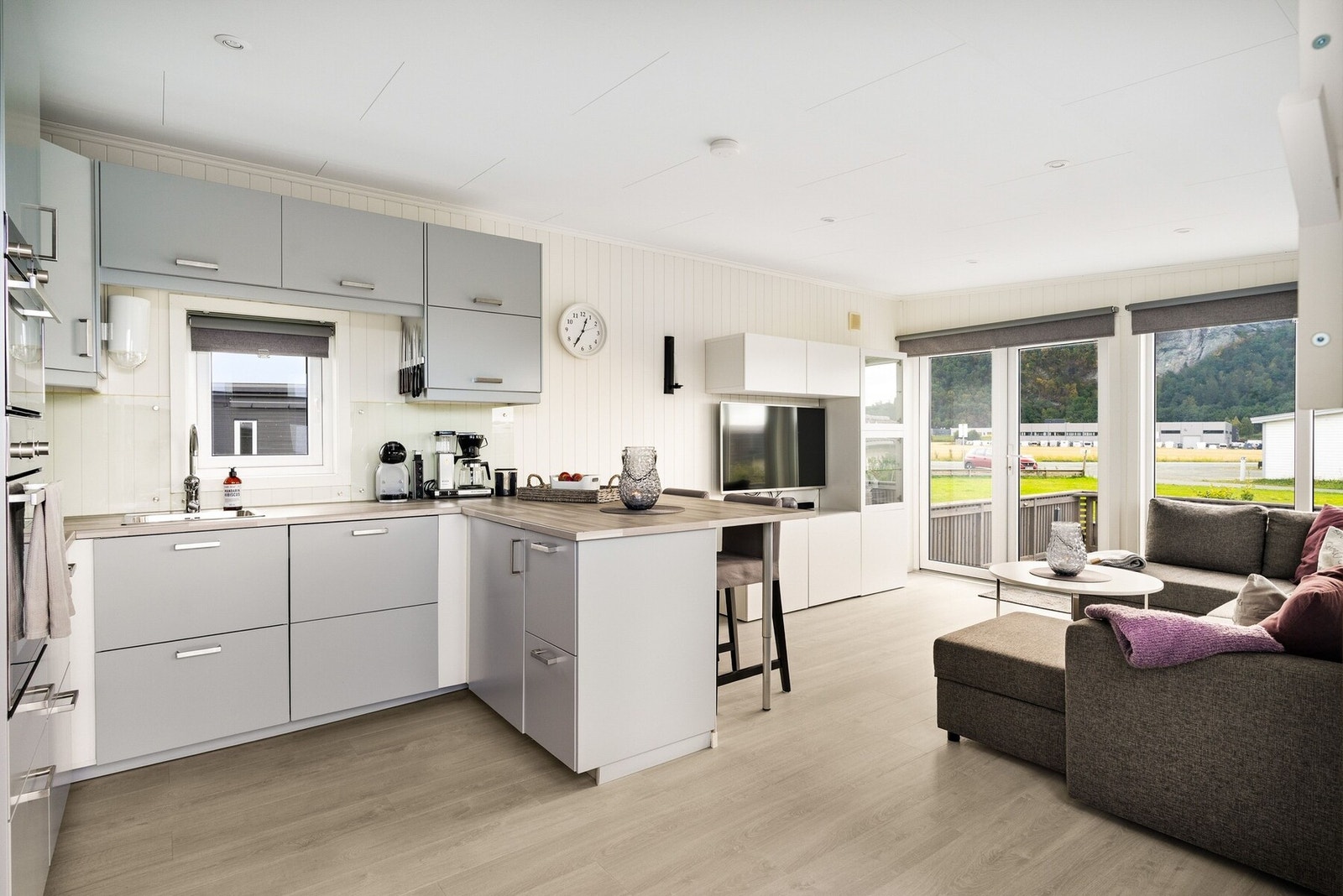 Spesiallaget bred benkeplate som skiller stue og kjøkken, og fungerer som praktisk spiseplass. Galleribilde