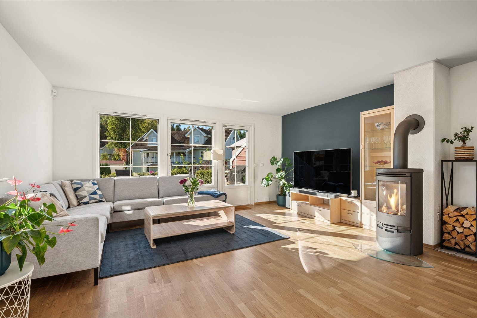 Romslig stue med peis og vinduer som gir masse innslipp av lys Galleribilde