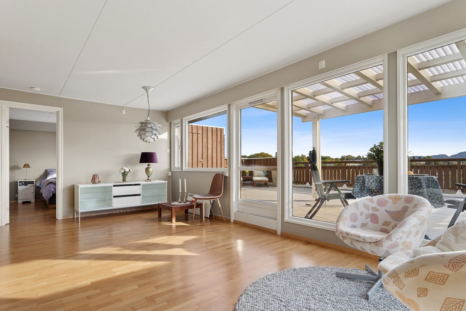 Vindusflatene og balkongdøren strekker seg over hele den ene veggen og slipper inn godt med naturlig lys. Galleribilde