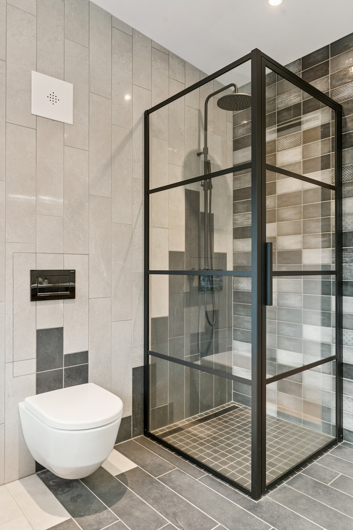 Baderommet er innredet med badekar, vegghengt toalett og dusjhjørne. Galleribilde