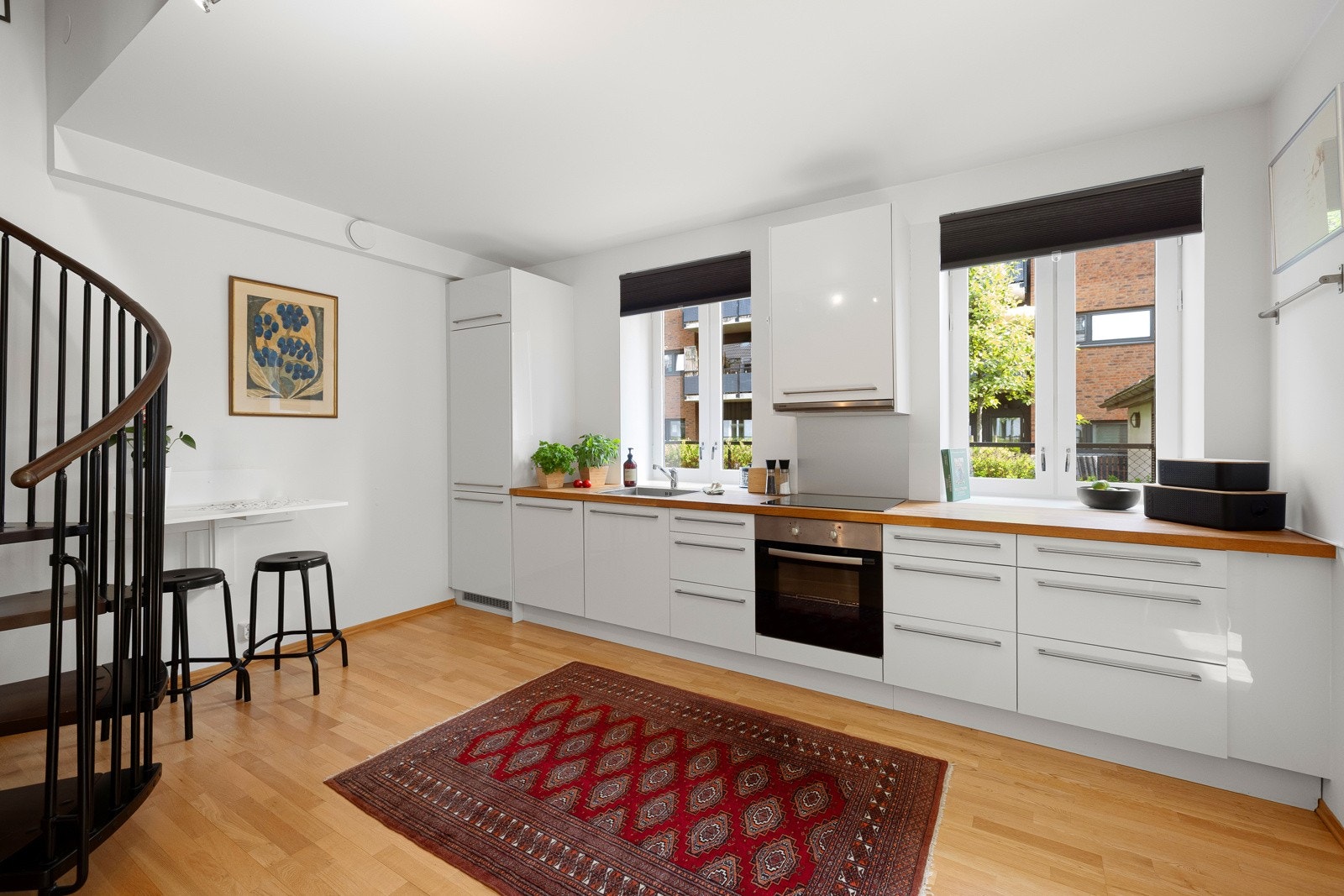 Stilrent kjøkken med hvite fronter og godt med benkeplass. Gode oppbevaringsmuligheter i skuffer og skap. Galleribilde