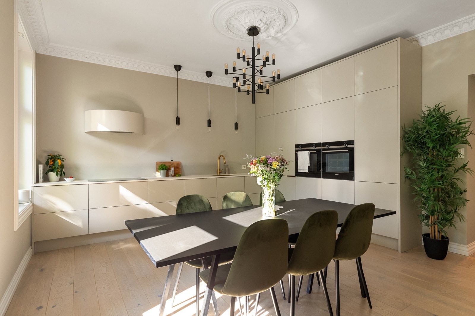 Kjøkkeninnredningen har lyse fronter, benkeplate i komposittstein med underlimt kum i messing og hengende lysarmatur fra himling. Galleribilde