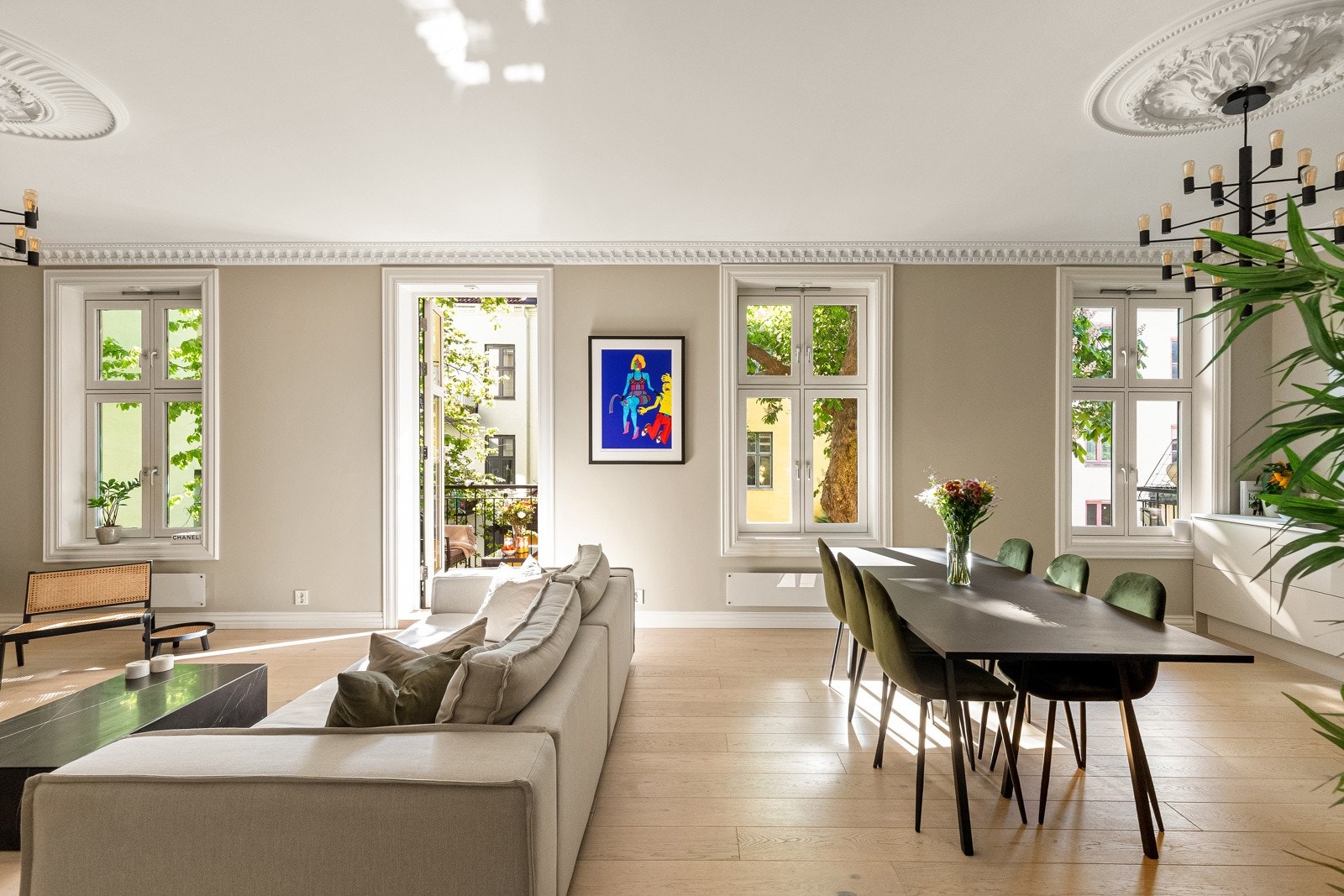 Fra de store klassiske vinduene får man et fint, glitrende lys fra sollyset som skinner gjennom de store grønne trærne i gårdsrommet. Galleribilde