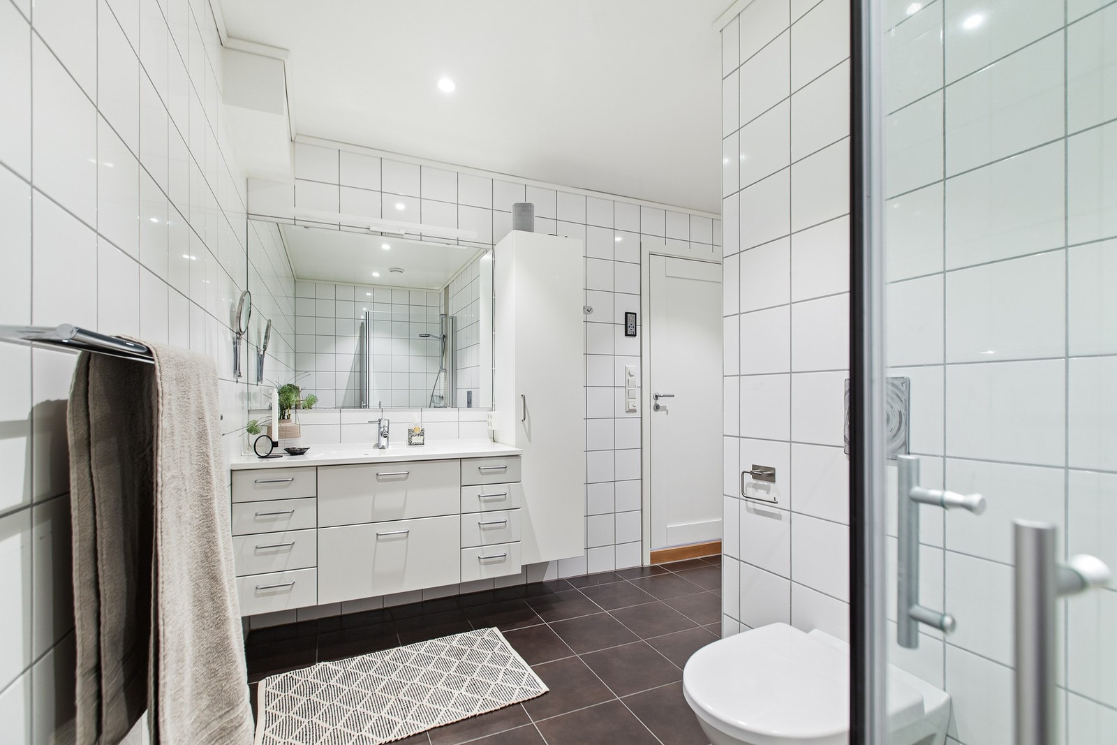 I underetasjen har man enda et pent og romslig flislagt bad. Badet har gulvvarme, vegghengt toalett, badekar, dusjnisje og servant med speil. Galleribilde