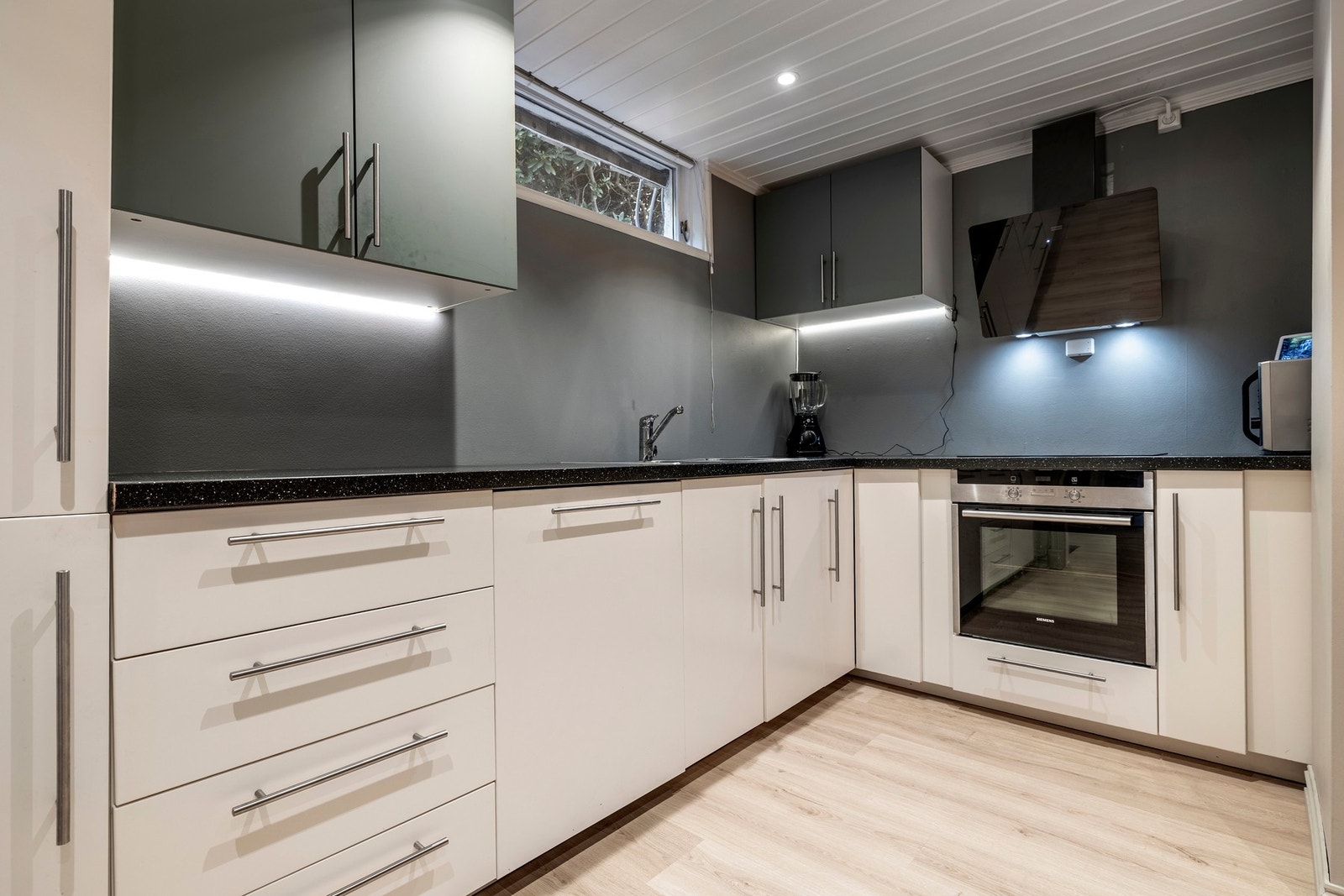 Kjelleren har eget kjøkken med ny innredning fra 2018. Kjøkkenet har integrert koketopp, stekeovn, kjøl/frys og oppvaskmaskin. Over kokesonen er det montert en sort ventilator fra 2025 med glassfront. Galleribilde