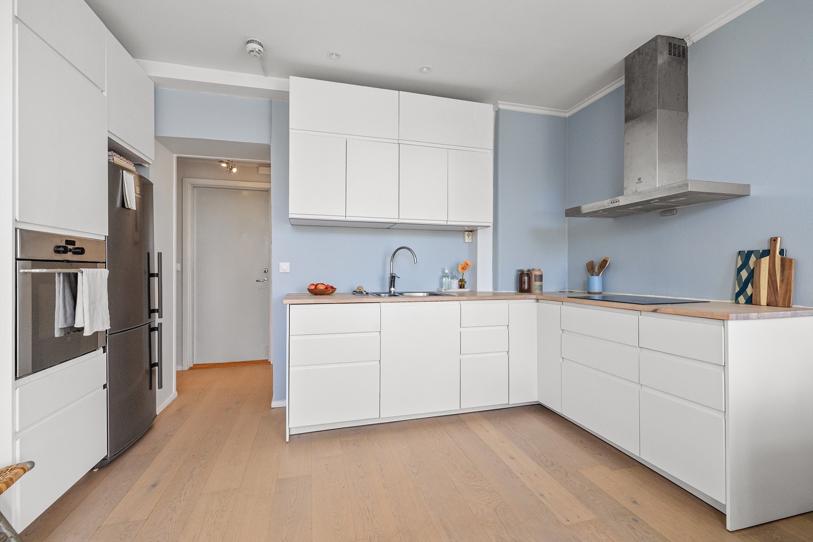 Lys innredning med glatte, hvite fronter og heltre benkeplate. Galleribilde