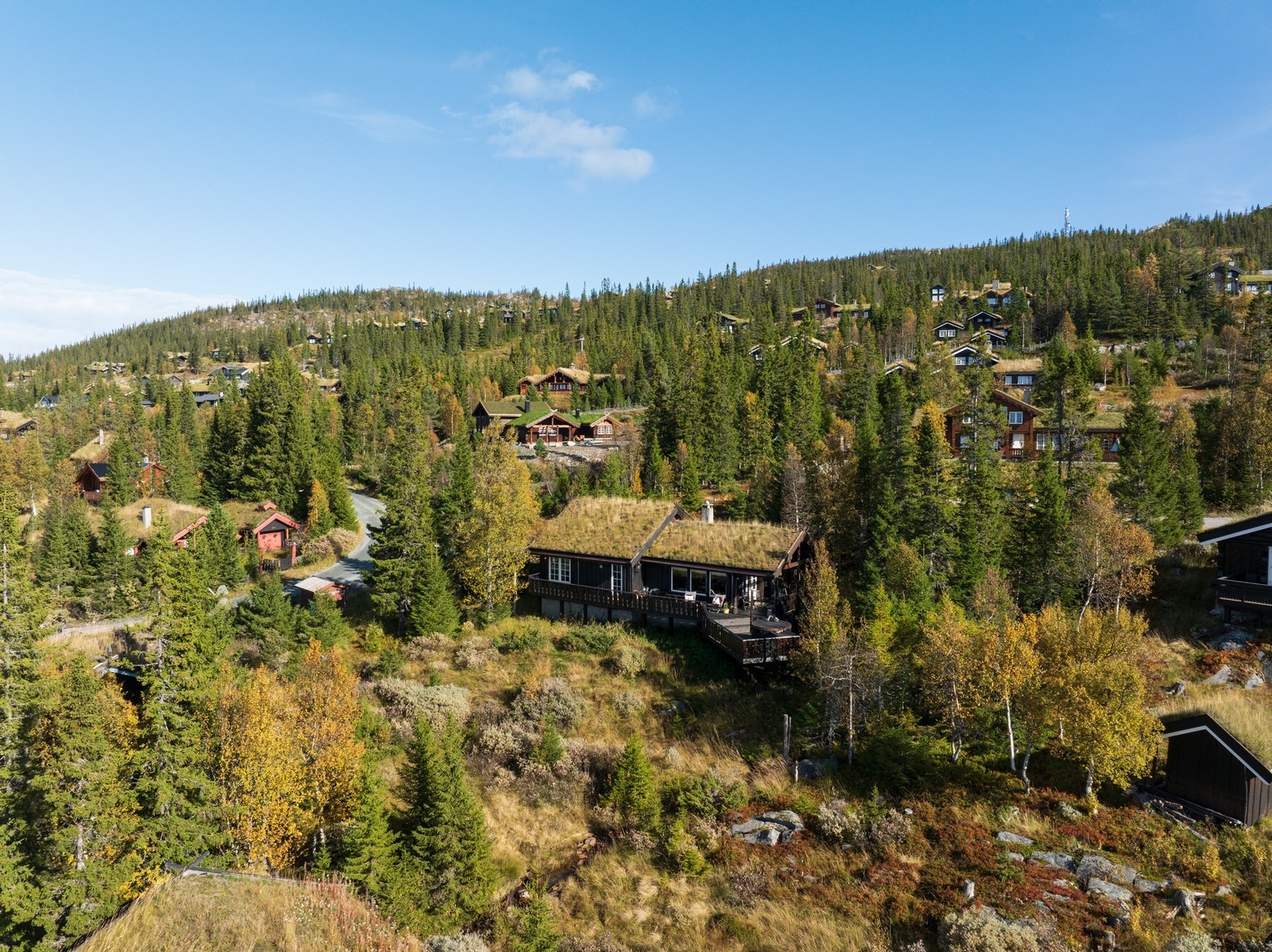 Torvtaket og trekledningen understreker hyttas klassiske fjellpreg. Galleribilde
