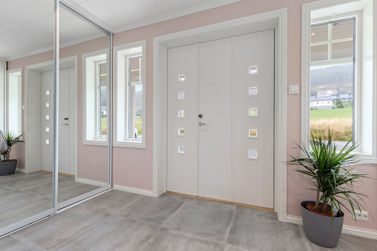 Velkommen inn i en romslig entre med skyvedørsgarderobe Galleribilde