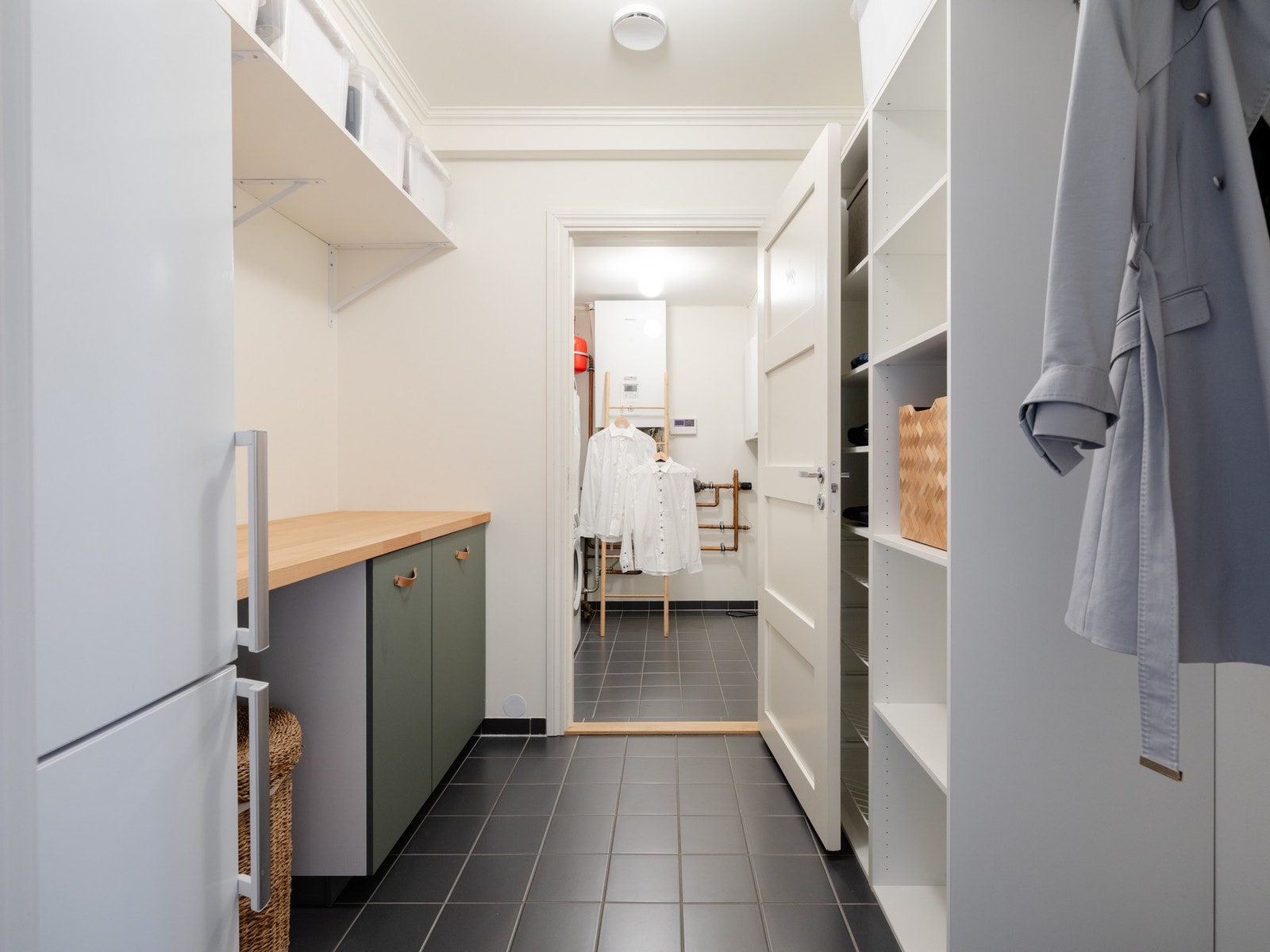 Her er det godt med oppbevaring i form av flere hyller, skap og benkeplass. Kjøleskapet medfølger. Galleribilde