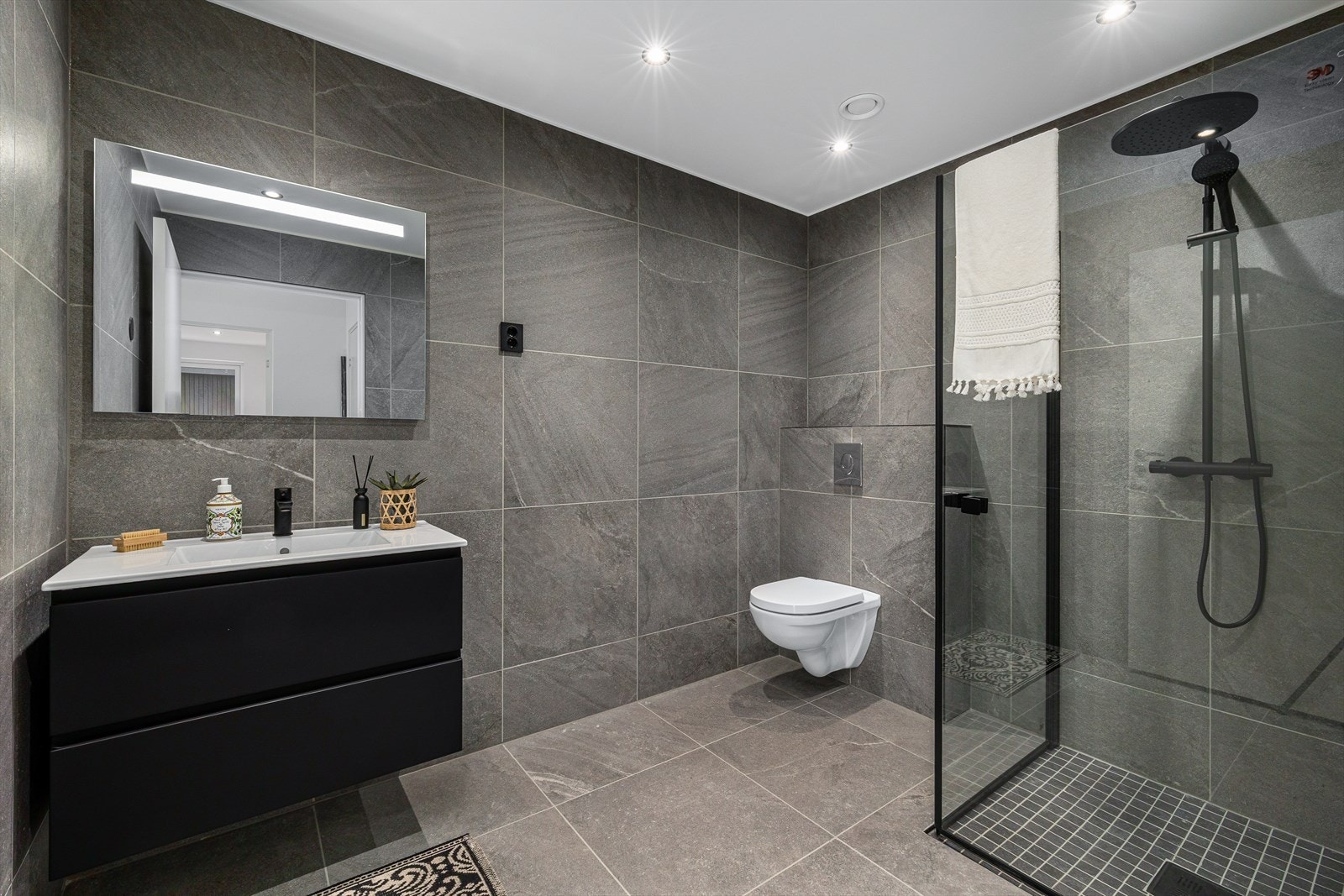 Tilhørende barnerommene ligger et eget bad. Badet er pent innredet i samme stil som hovedbadet og gulvflisene i hallen. Det er varme i gulv og utstrakt bruk av downlight i himling. Galleribilde