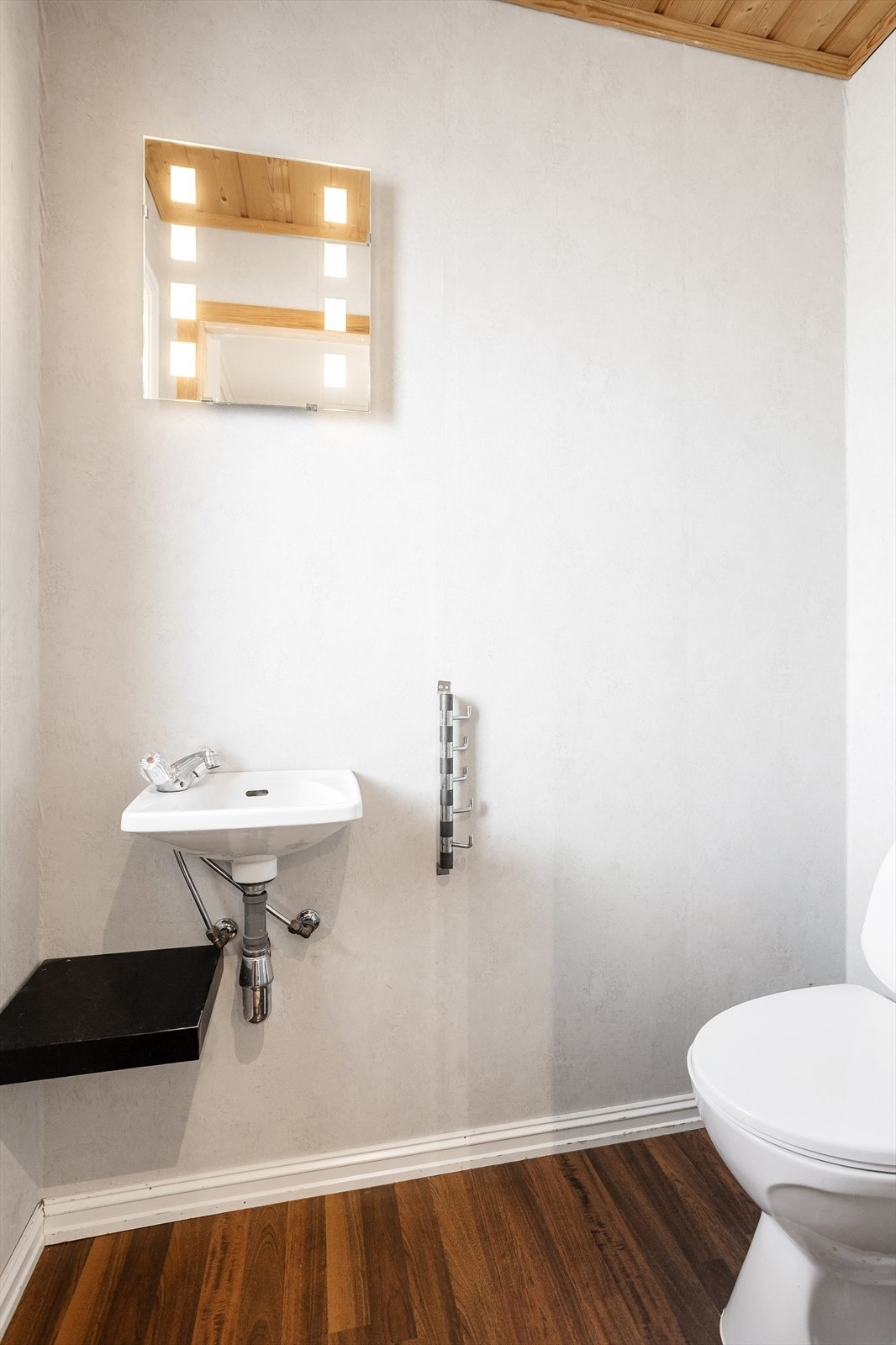 Stilrent toalettrom med moderne overflater og speil med integrert belysning. Galleribilde