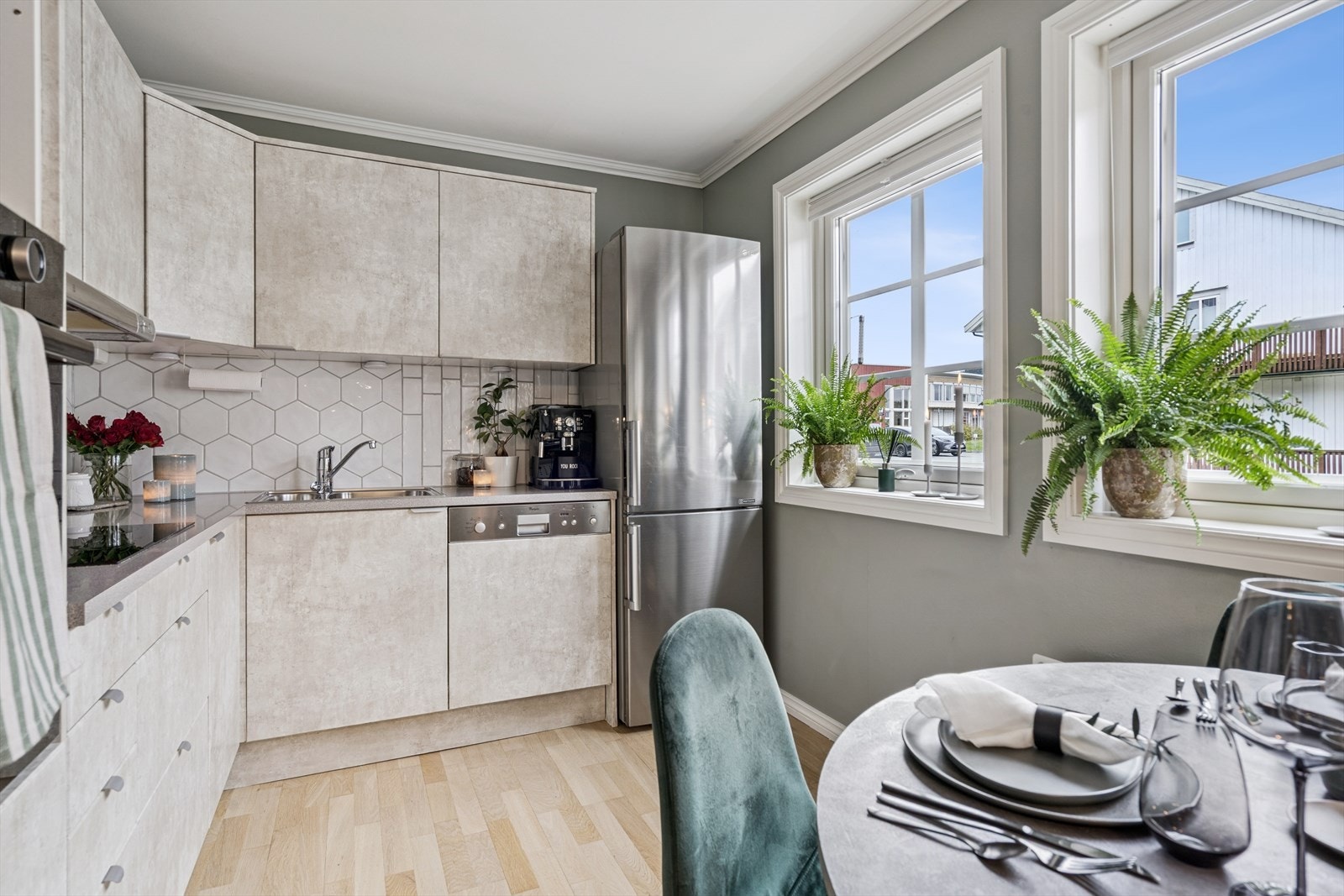 Gjennom kjøkkenvinduene får man rikelig med naturlig lys-innslipp. Flisene på kjøkkenet er fra 2022. Galleribilde