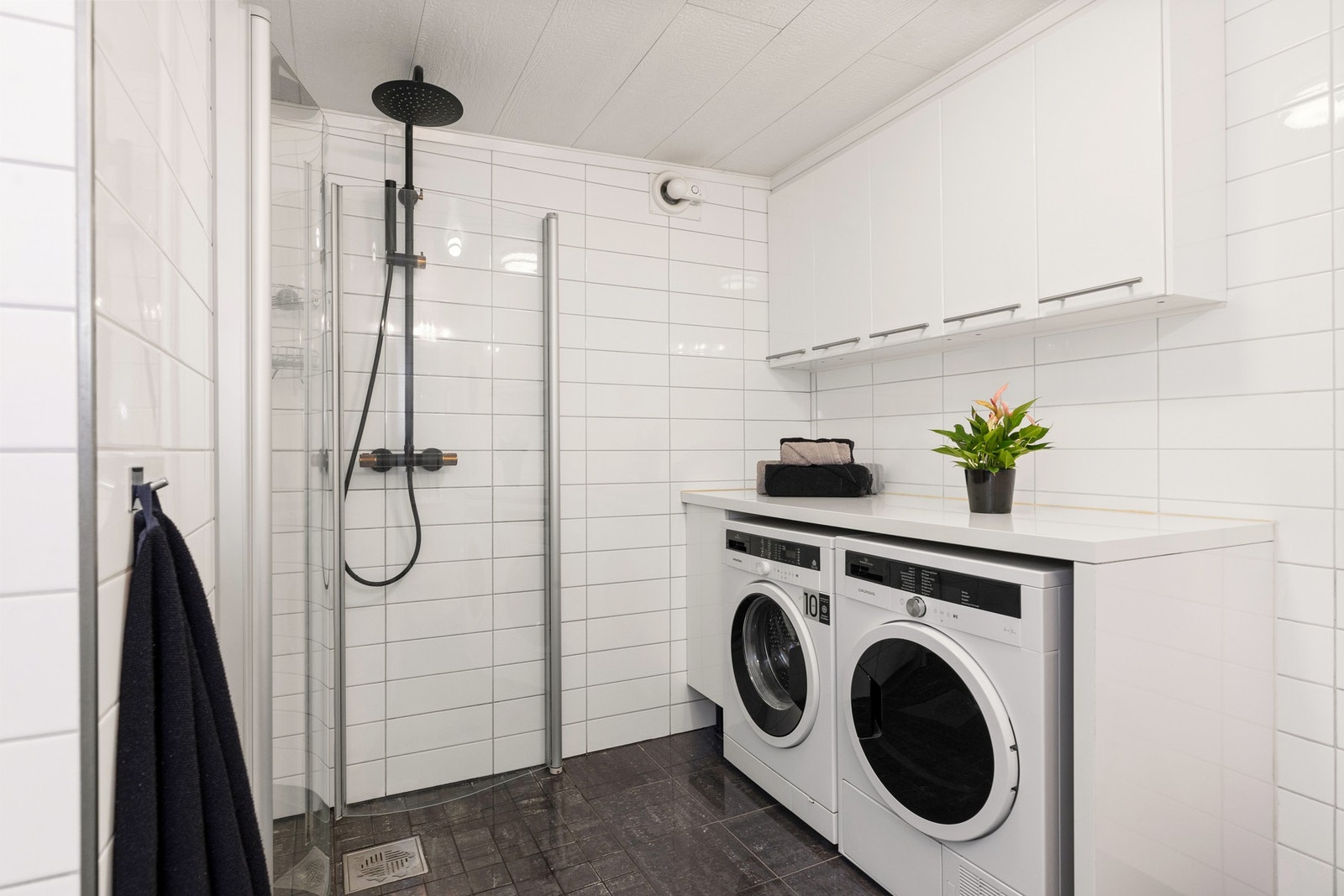 Rommet er innredet med nedfelt servant, vegghengt toalett, dusjhjørne og opplegg for vaskemaskin. Galleribilde