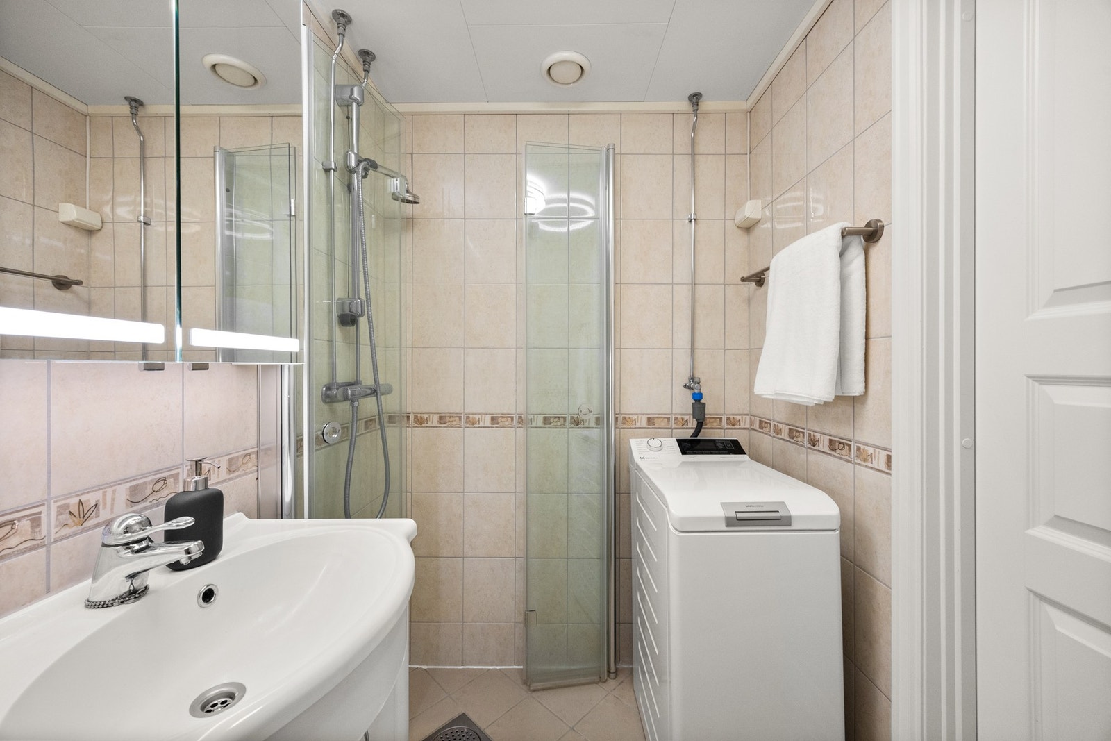 Vegghengt speil med belysning som ble utskiftet i 2023. Hylleløsning og skuffene under vasken passer godt til toalettsaker og diverse. Galleribilde