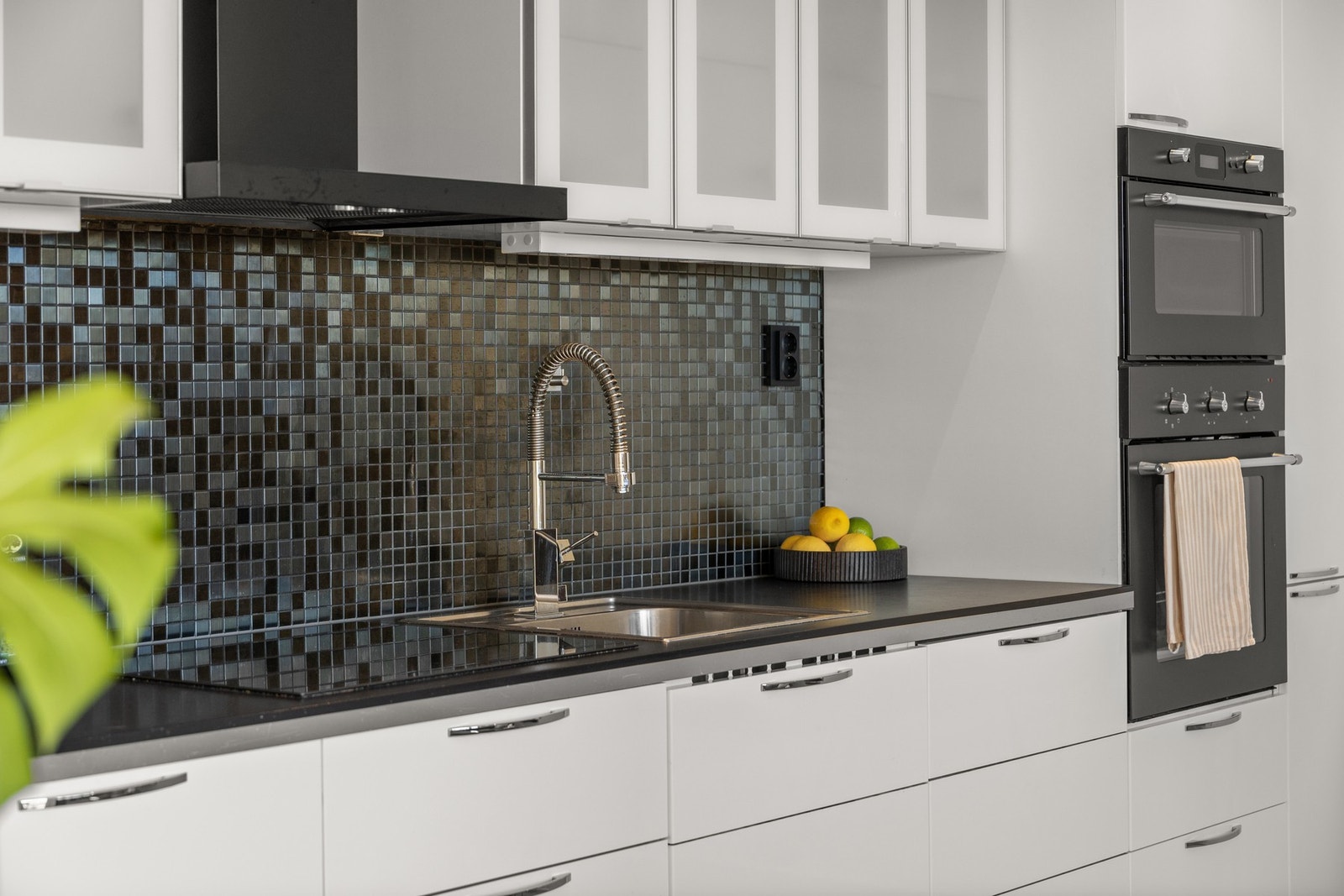 På veggen mellom kjøkkenbenken og høyskapet er det flislagt, og det er tilgang på stikkontakt for kaffemaskin samt andre kjøkkenmaskiner. Galleribilde