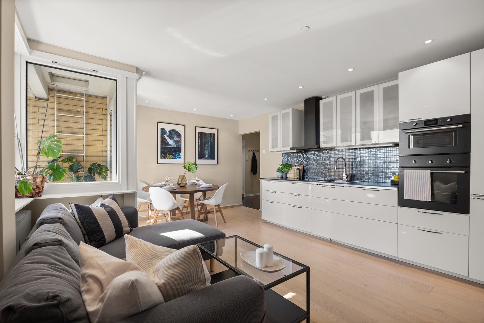 Pent kjøkken bestående av hvite skapfronter og laminert benkeplate. Galleribilde