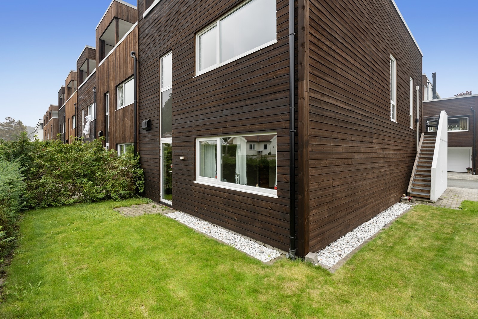 Tomten er pent opparbeidet med en lettstelt plen og direkte adgang til balkongen foran stuen Galleribilde