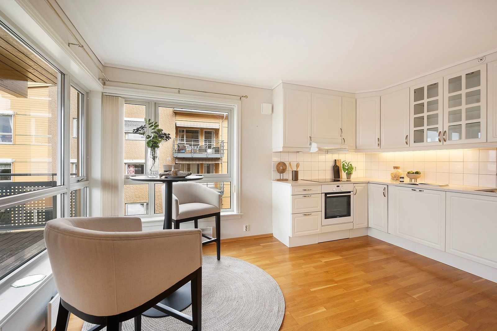 Lyst og innbydende kjøkken med store vindusflater Galleribilde