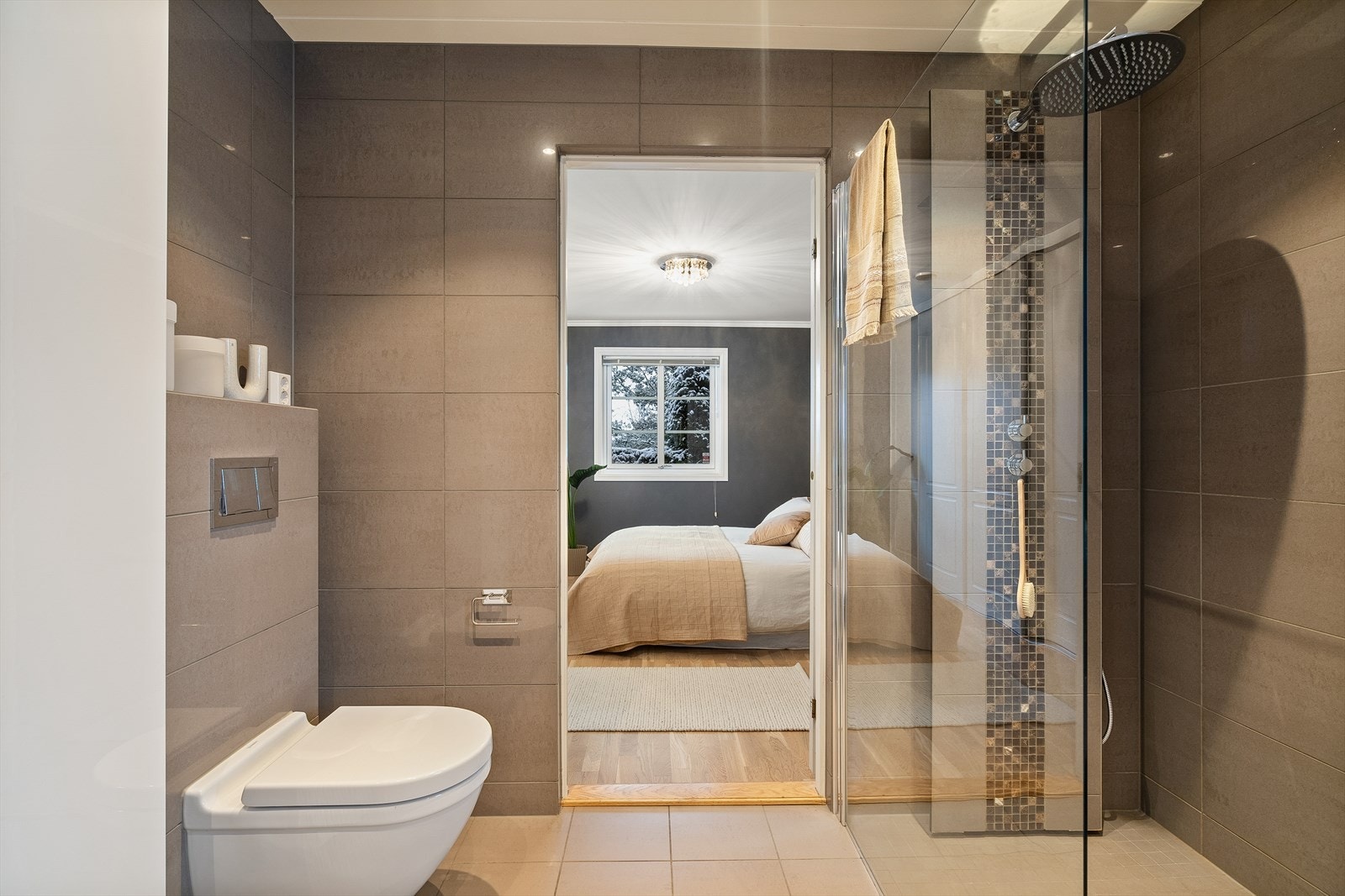 Dusjnisje er utstyrt med mosaikkfliser, regnfallsdusj og en vegg i herdet glass Galleribilde