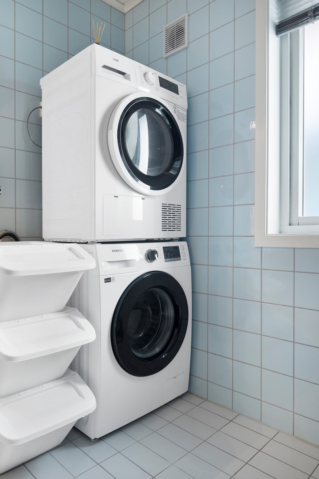Bad med malte takplater, fliser på vegger og gulv, innredning med wc og dusjkabinett, samt opplegg for vaskemaskin og stikkontakt til tørketrommel. Galleribilde