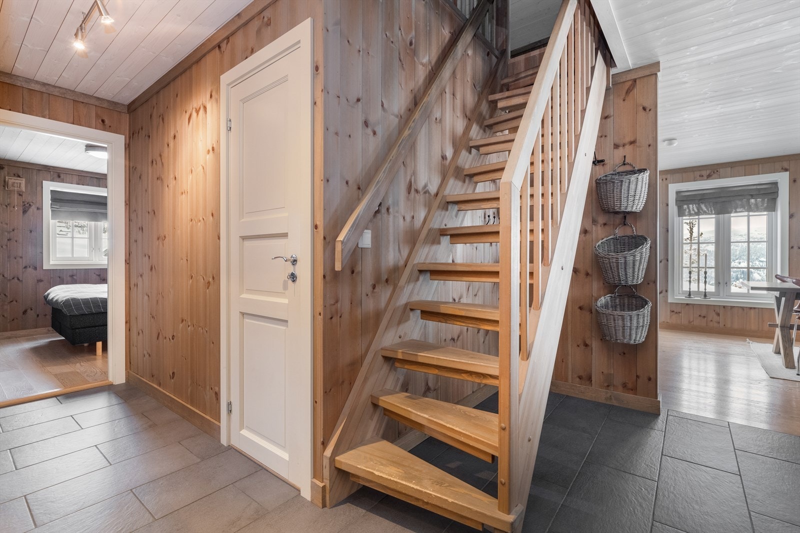 I hallen er det praktiske flis på gulv. Det er inngang til bod og trapp opp til fritidsboligens 2. etasje. Galleribilde