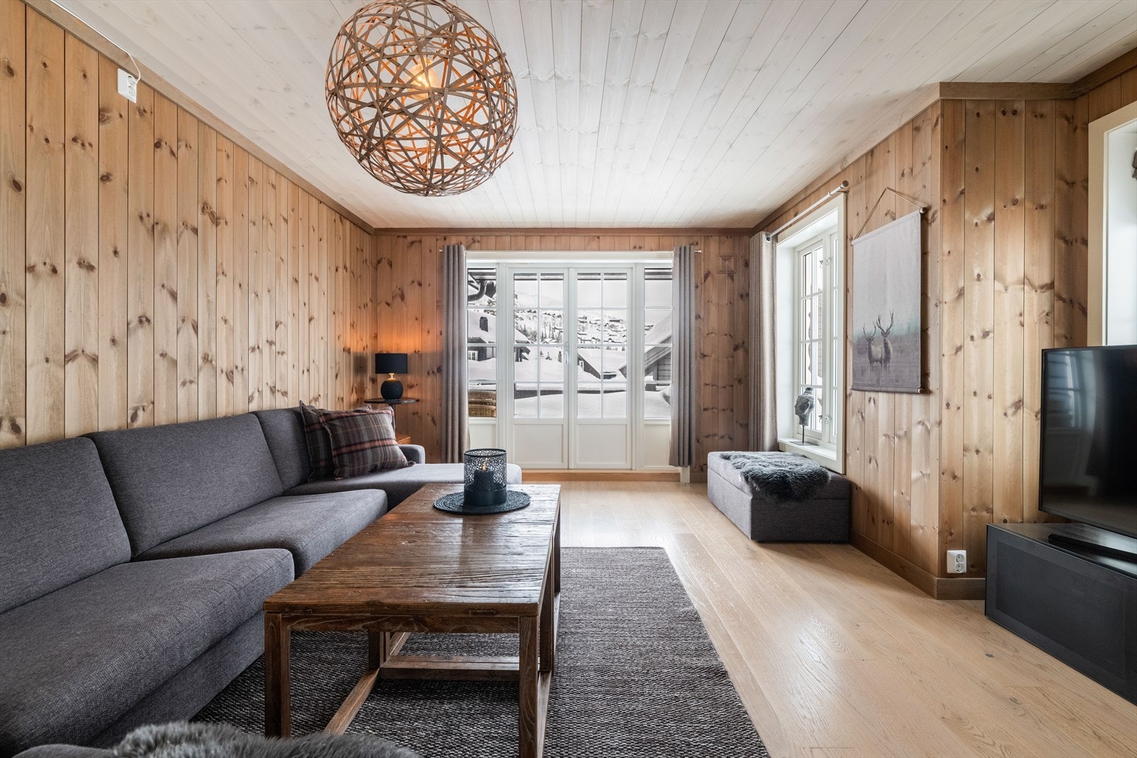 Stuen har pene overflater med parkett på gulv og panel på vegger, som er gjennomgående for store deler av fritidsboligen. Galleribilde