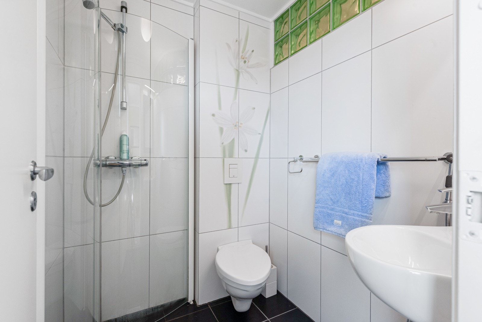 Lyst og lekkert bad med fliser på gulv og vegg Galleribilde