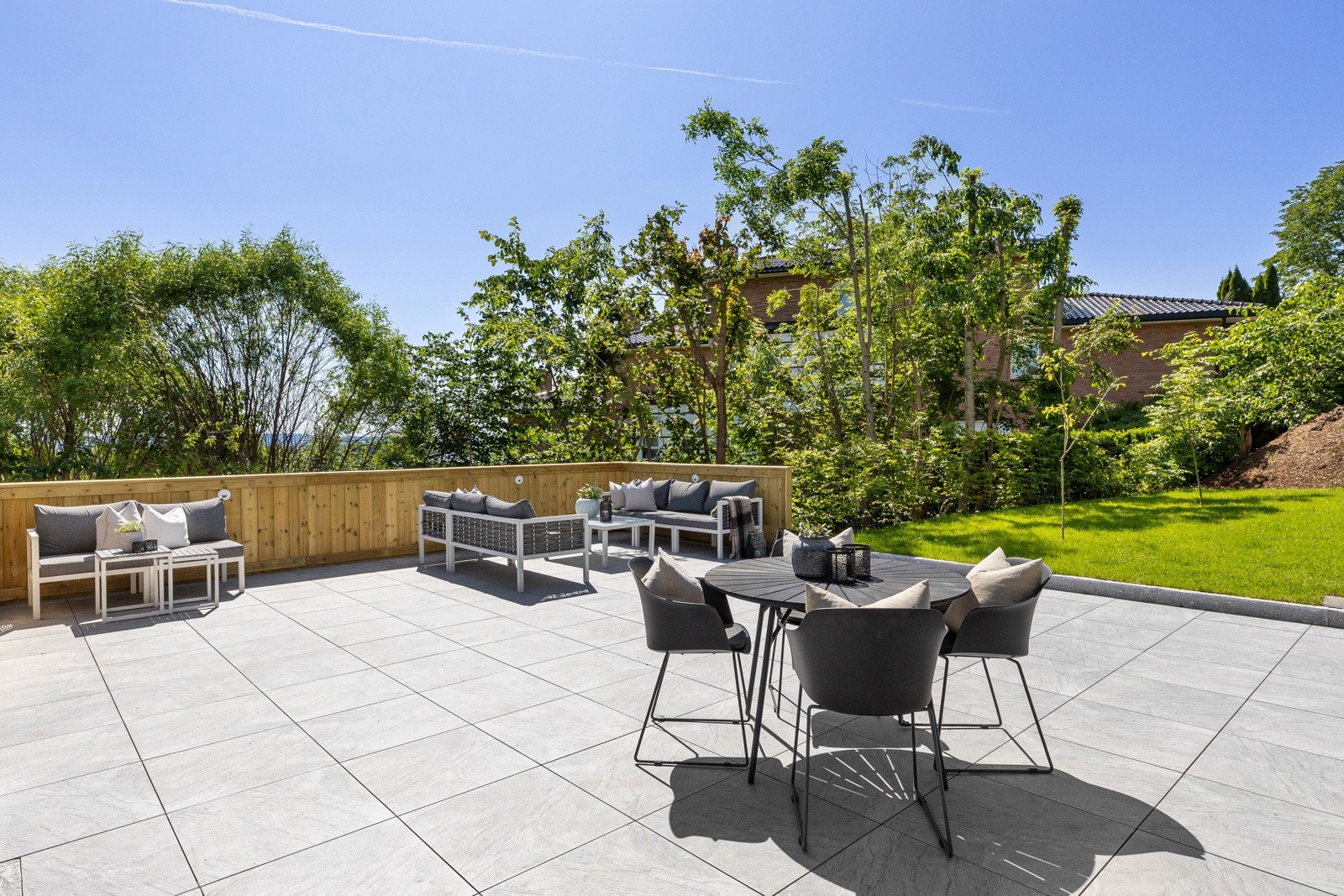 Ut fra spisestuen eller fra utsiden av huset kommer du til en generøs og tilbaketrukket uteplass Galleribilde