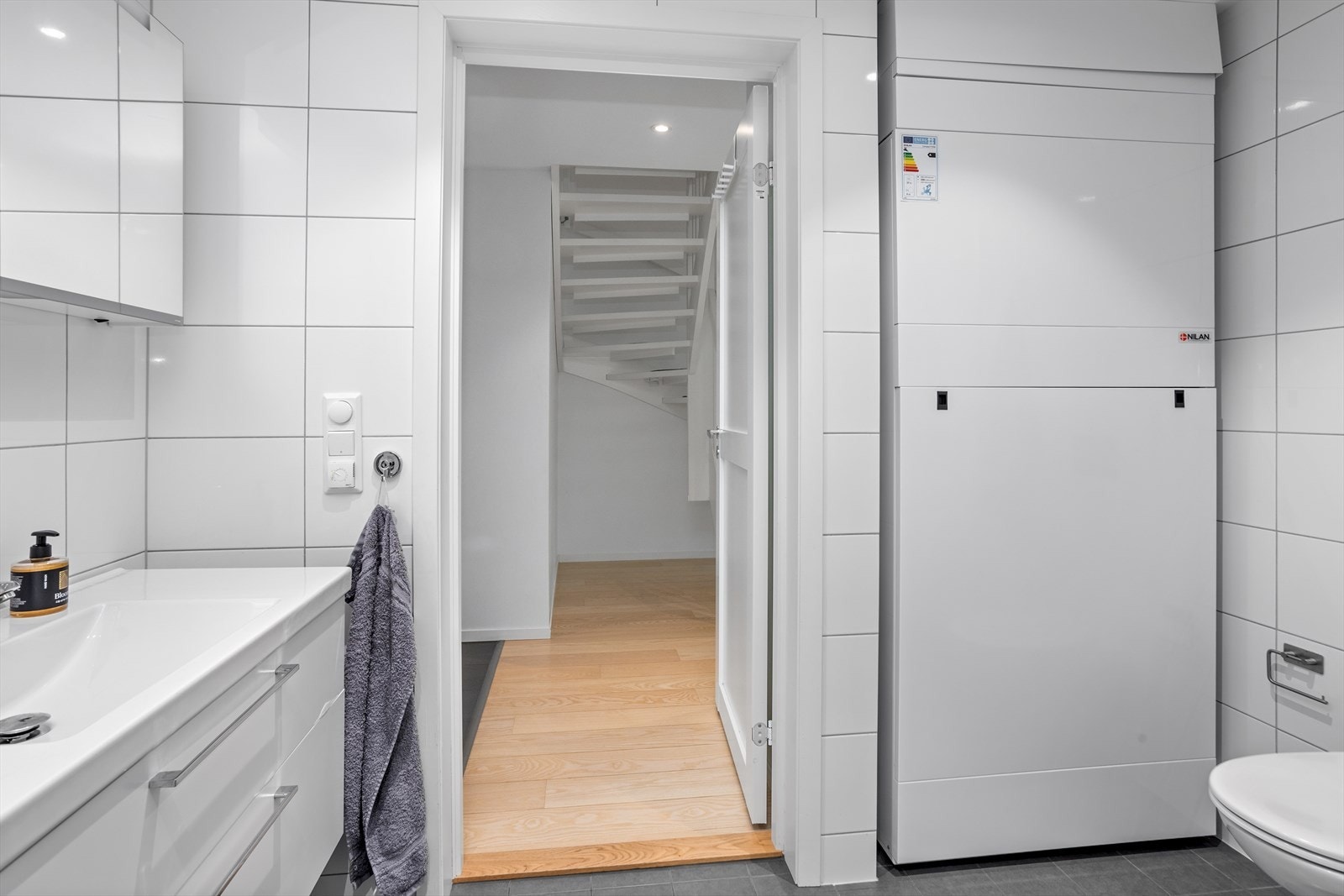 Baderomsinnredningen i begge baderommene har servantskap med doble kolonialskuffer og fronter i hvit høyglans. Nilan anlegget er plassert i nisje på baderommet i 1. etasje. Galleribilde