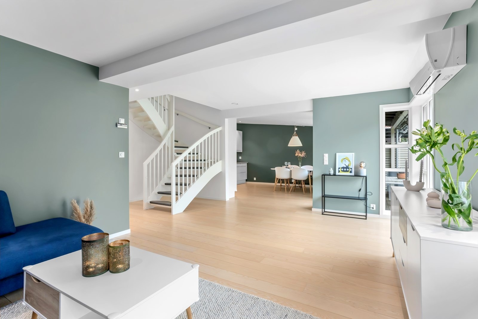 Det åpne trapperommet, som også er en del av stue-/kjøkkenarealet, har også innfelte downlights i taket. Varmepumpen fra 2021 tilfører energiøkonomisk varme i vinterhalvåret og gir mulighet for sval luft på hete sommerdager. Galleribilde