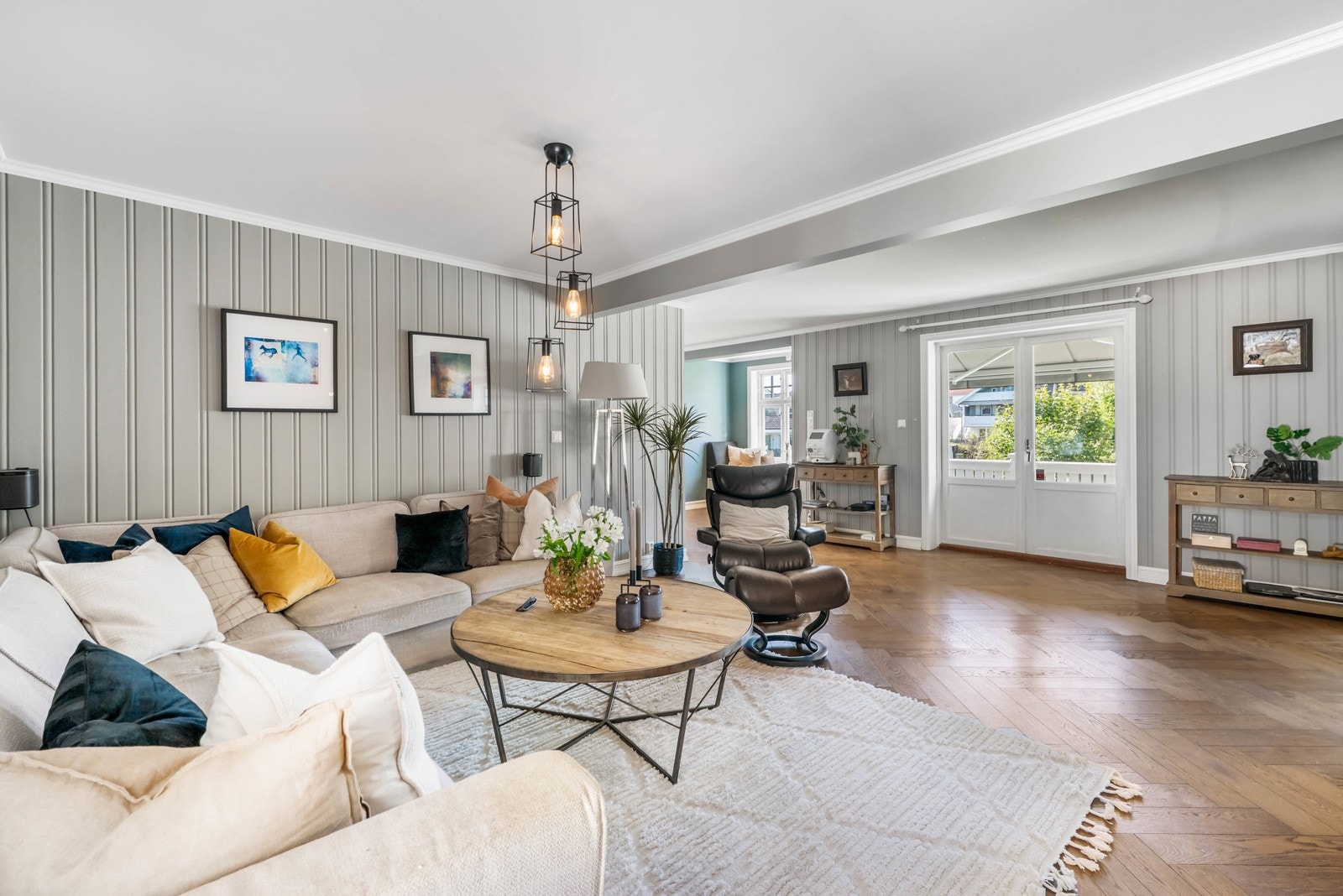 Stua har ildsted med glassfelt fra flere sider. Her får man med seg peisen enten man leser en bok i kroken, sitter i stua eller er på kjøkkenet. Galleribilde