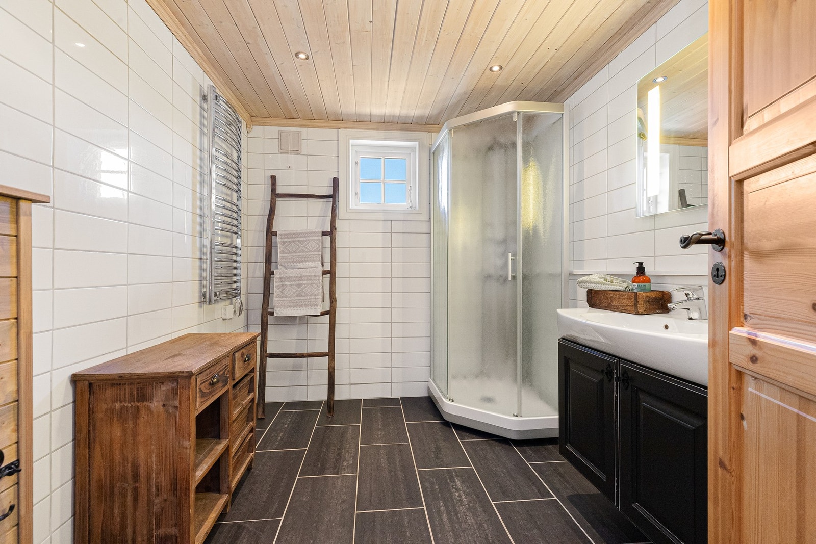 Begge bad er i første etasje. Hovedbad med flislagte overflater på vegger og gulv Galleribilde