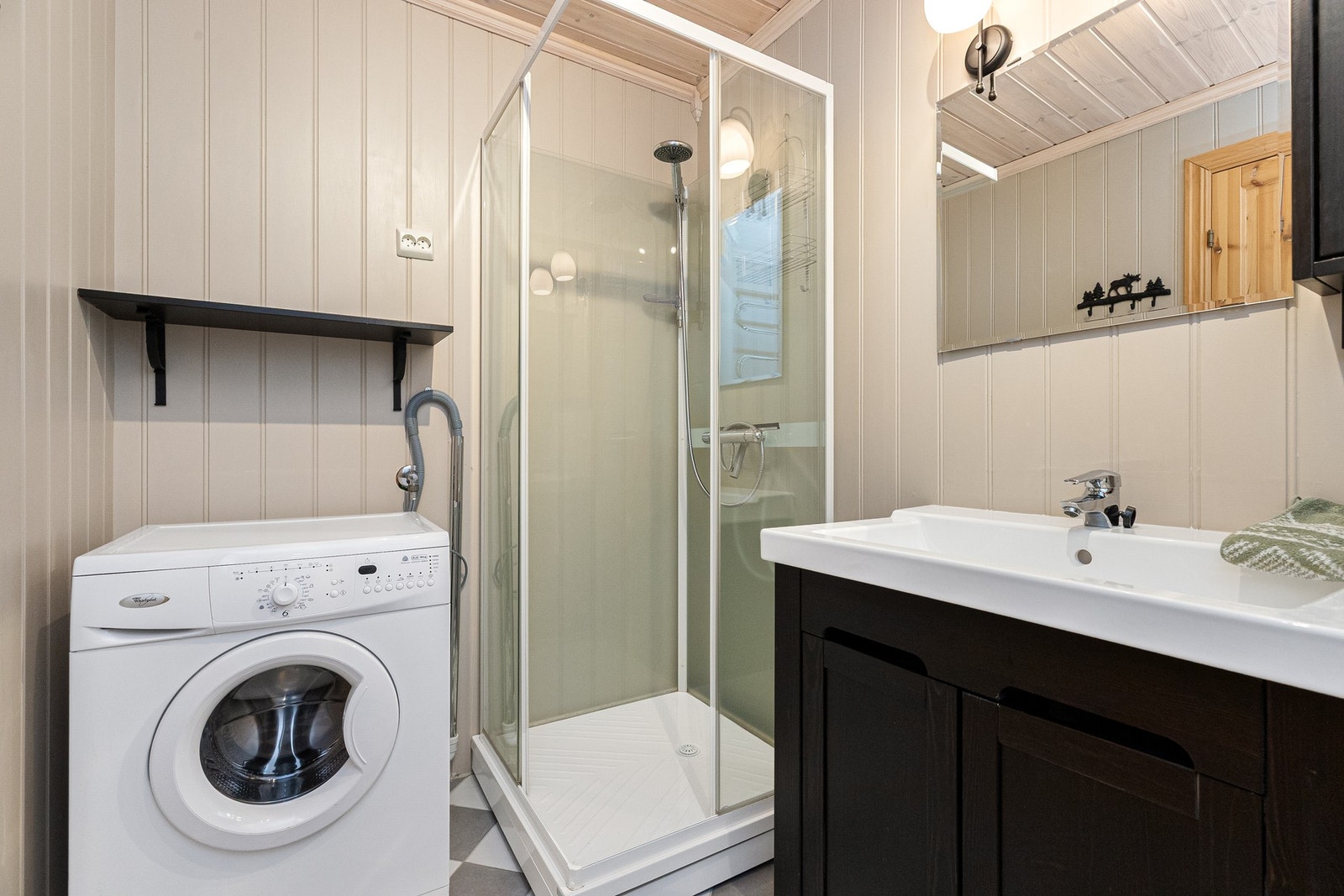 Det andre badet er kombinert vaskerom, her er det panel på veggene og flislagt gulv Galleribilde