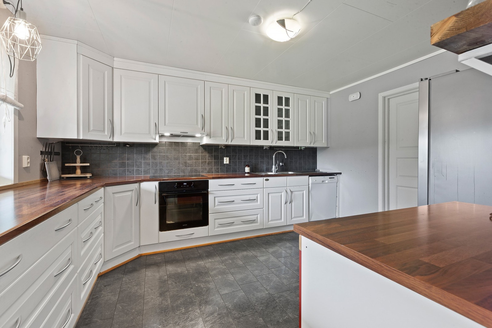 Innbydende kjøkken med profilerte MDF-fronter, rikelig med skap og skuffer, og god benkeplass - perfekt for matlaging sammen Galleribilde