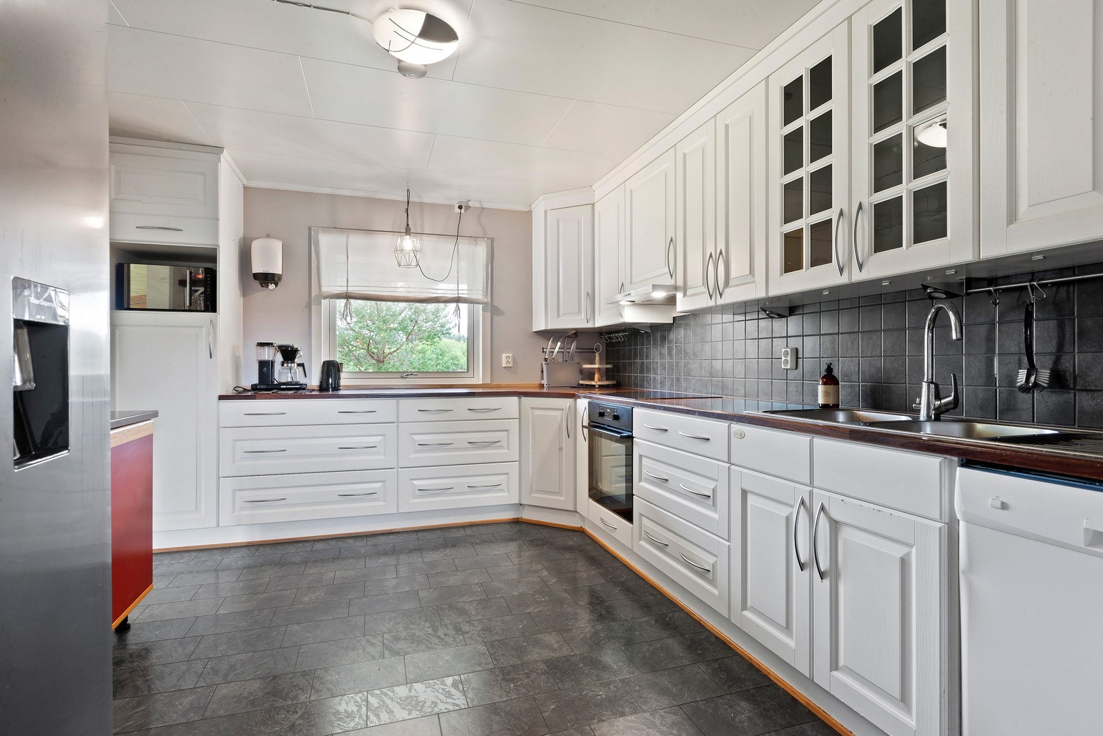 Romslig kjøkken med lys innredning, godt med skap, skuffer og arbeidsflater. Oppvaskmaskin, komfyr og platetopp medfølger. Galleribilde