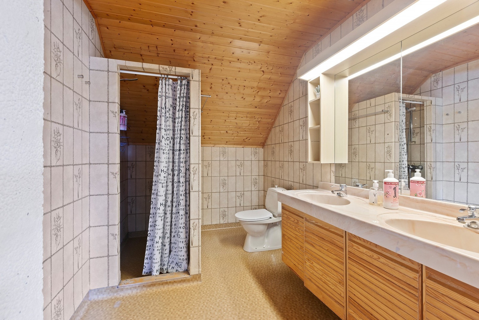 Bad på loft har Innredning med 2 integrerte servanter med skap under. 2 speilskap med lyslist over, dusjnisje og toalett, varme i gulv. Galleribilde