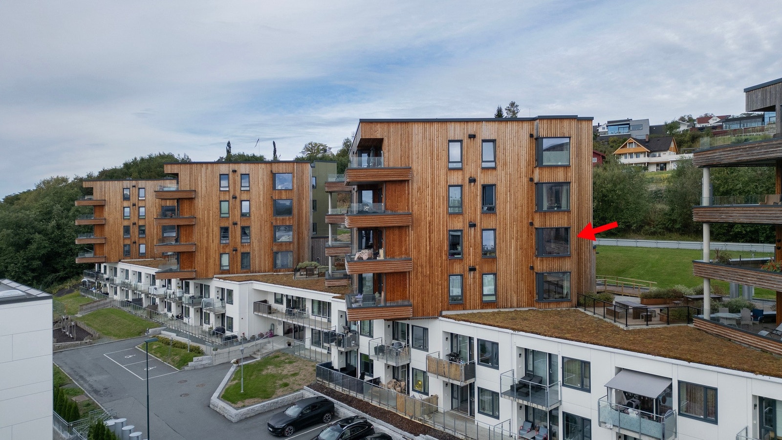 Dronefoto. Leilighetens plassering markert med rød pil Galleribilde