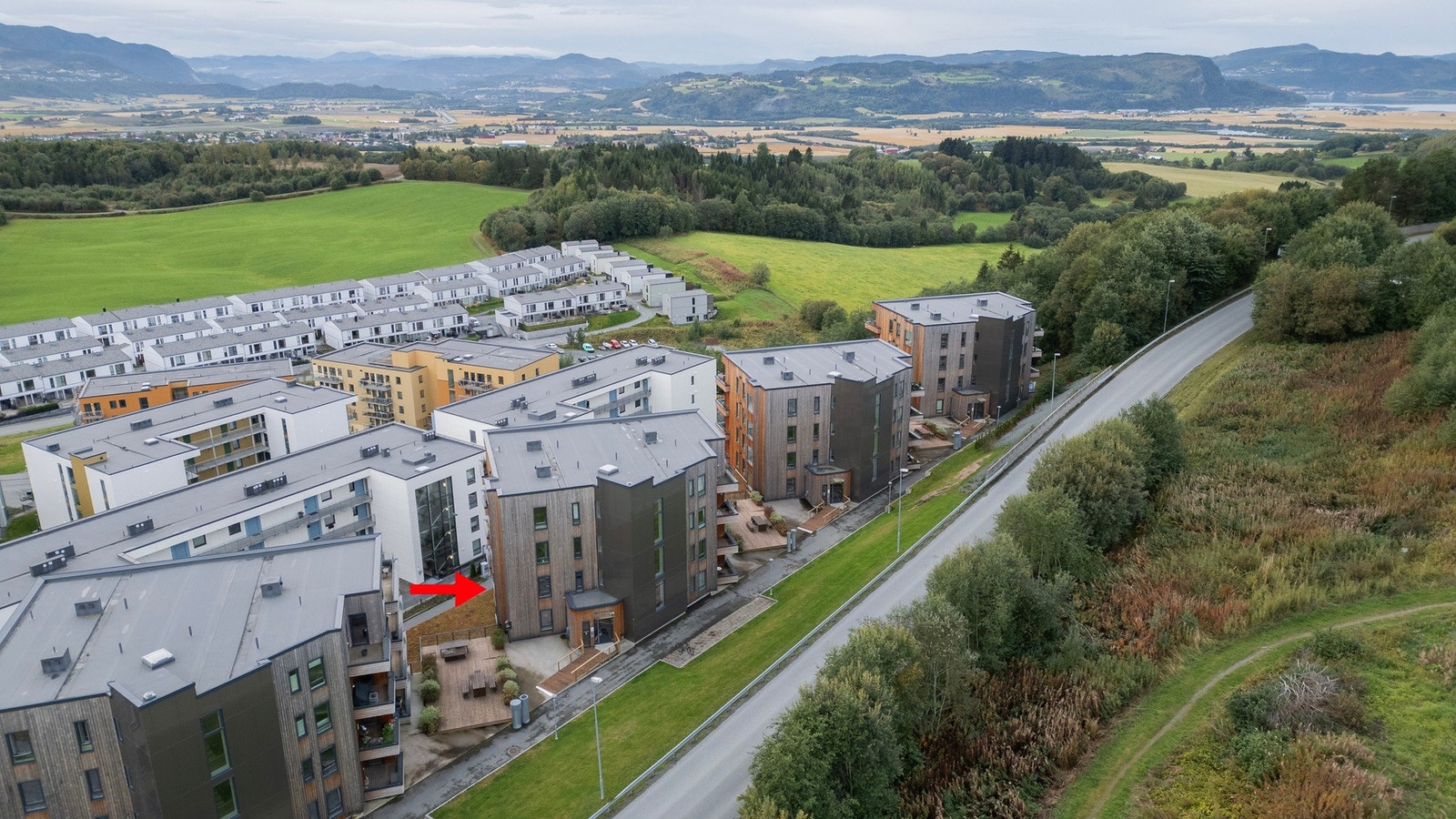 Dronefoto. Leilighetens plassering markert med rød pil Galleribilde
