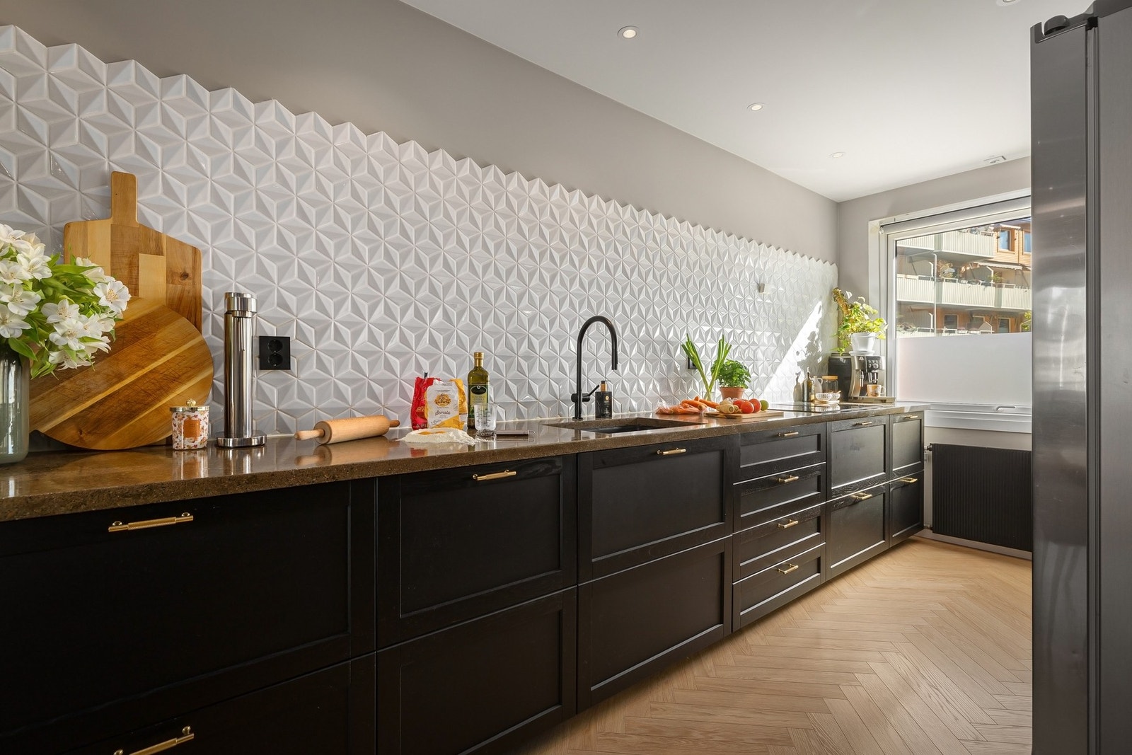 Innredning med profilerte fronter og støpt benkeplate med fliser på vegg over benk Galleribilde