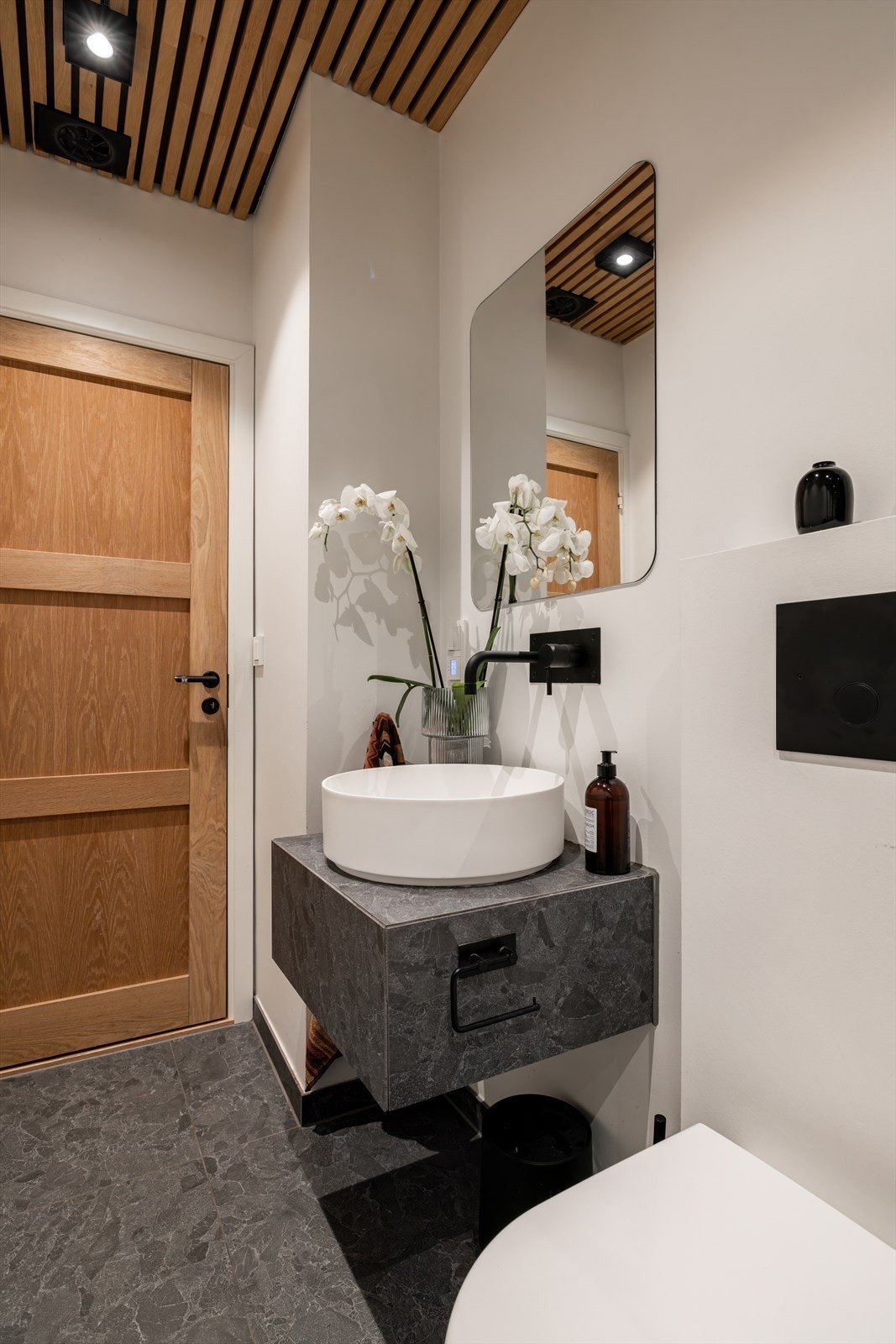 Innredet med vegghengt toalett, servant og speil Galleribilde