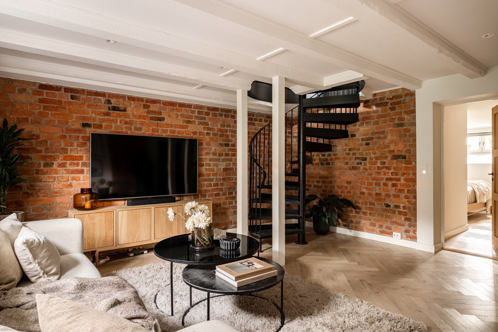 Teglsteinsvegg gir rommet særpreg og karakter, mens lysmalte vegger og fiskebensparkett med gulvvarme gir en lun og gjennomført stil Galleribilde