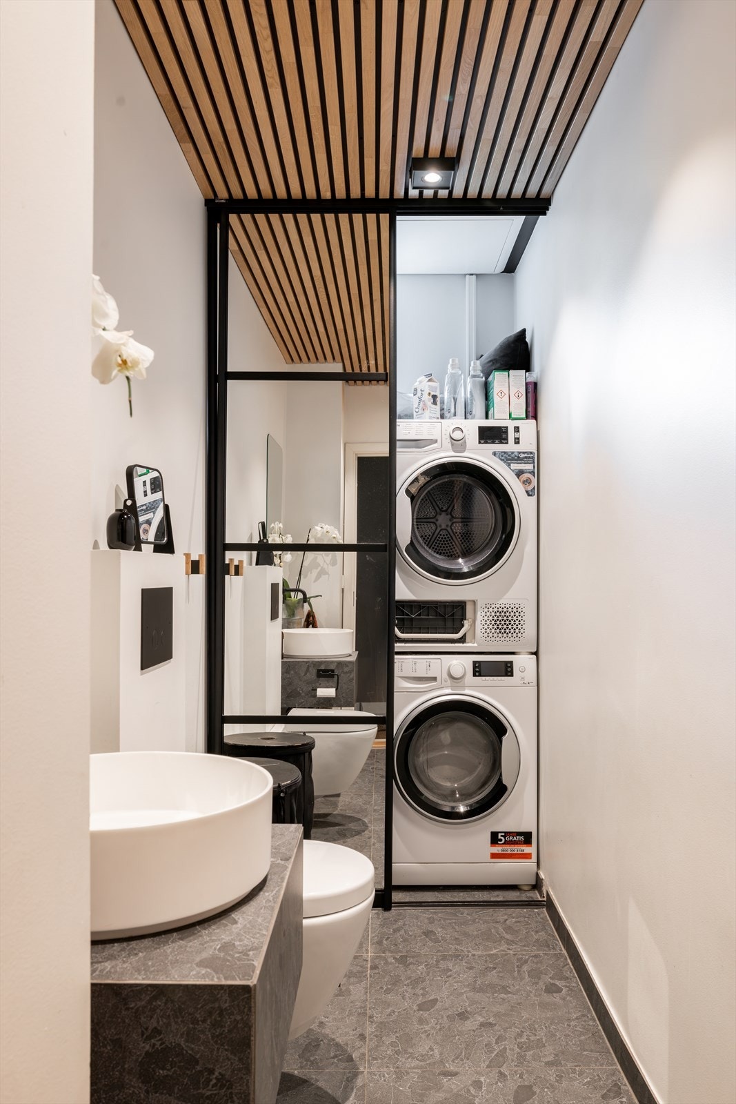 Bak en skyvedør finner du praktisk vaskesone med opplegg for vaskemaskin og tørketrommel Galleribilde