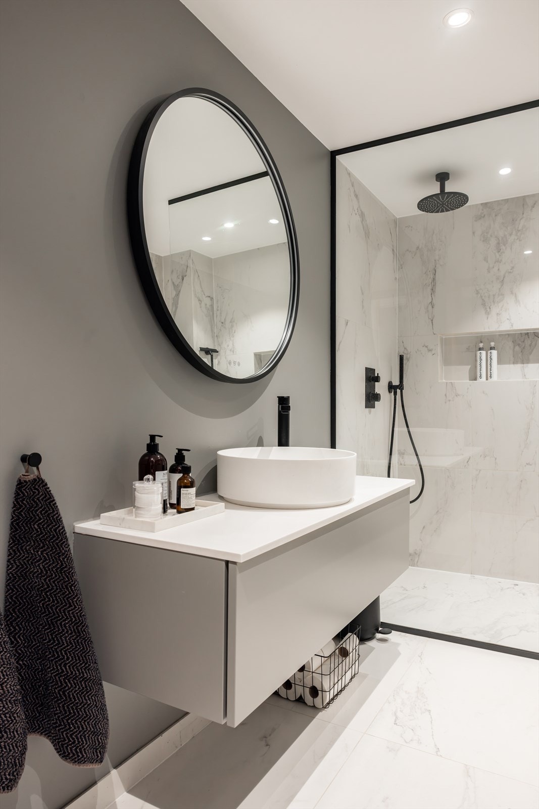 Badet er innredet med servant og underskap, speil, dusjhjørne med glassvegg og vegghengt toalett Galleribilde