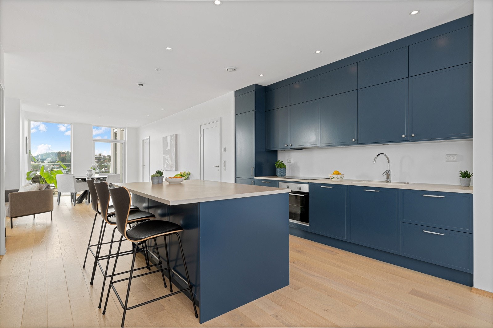 Kjøkkenet er utstyrt med integrerte hvitevarer og har god arbeidsflyt langs lyse benkeplater.