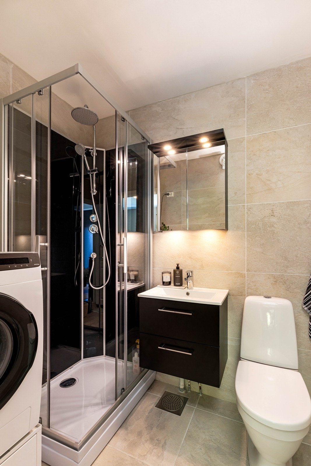 Badet er bl.a. innredet med dusjkabinett, vegghengt servantmøbel og vegghengt overskap med lys og speil. Galleribilde