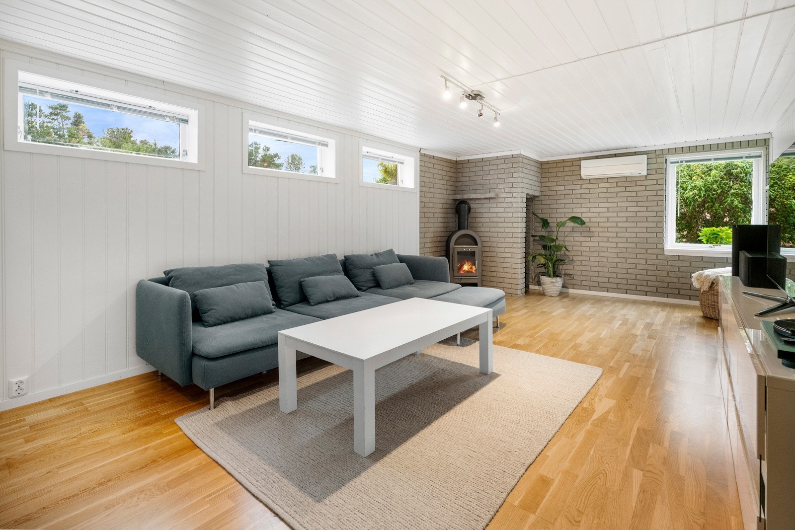 Gulvet er belagt med parkett, og veggene består av malte plater eller panel, noe som gir et lyst og nøytralt uttrykk. Galleribilde