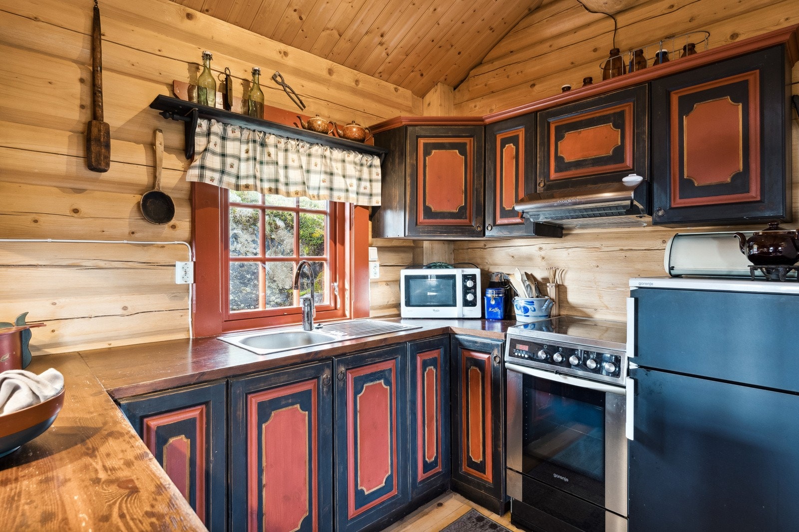 Plassbygd kjøkkeninnredning i heltre med profilerte fronter, heltre benkeplate og kjøkkenkos i stål. Galleribilde